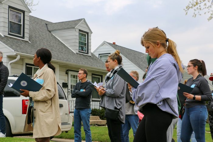 A group of people are standing in front of a house.