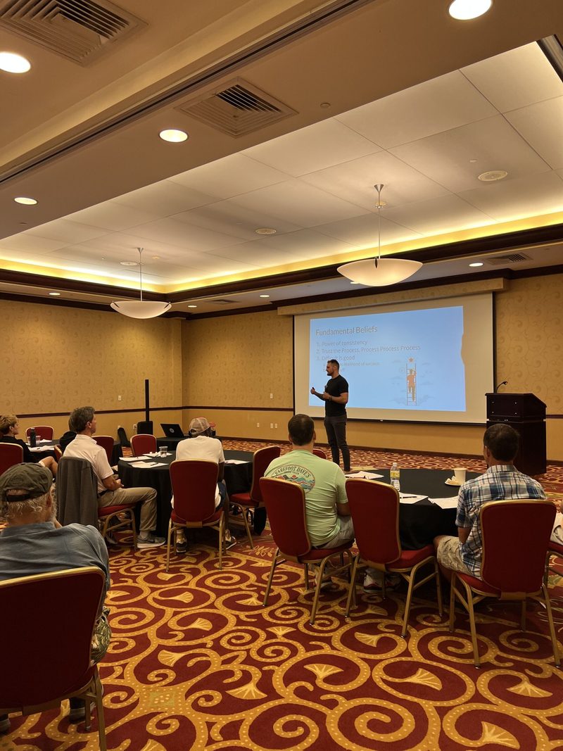 A man is giving a presentation to a group of people in a conference room.