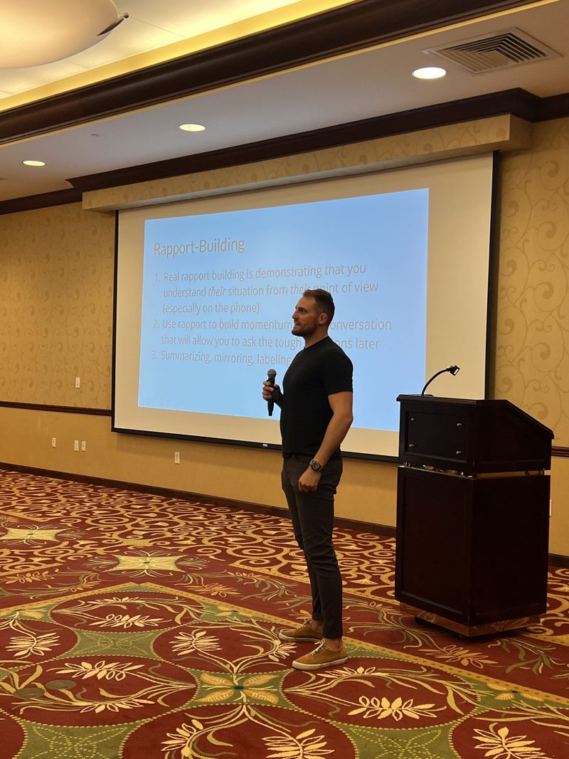 A man is giving a presentation in front of a large screen.