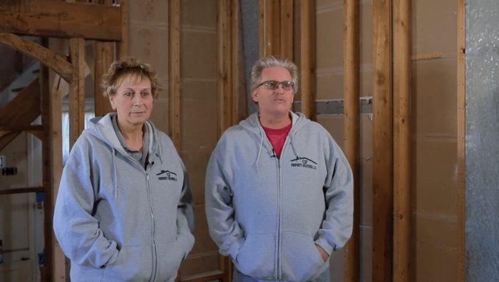 A man and a woman are standing next to each other in a building under construction.