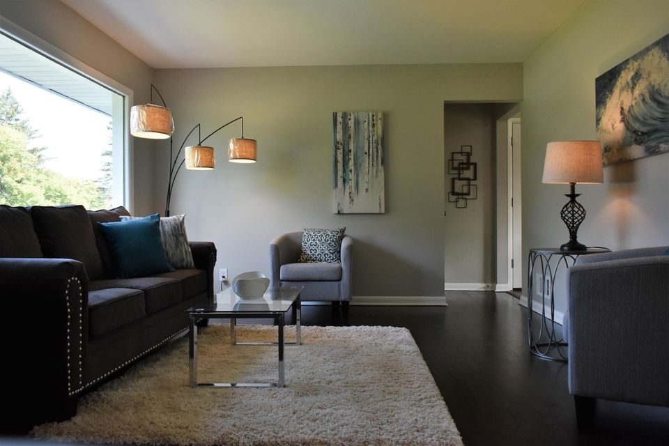 A living room with a couch and two chairs
