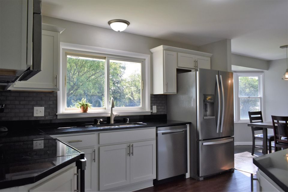 A kitchen with stainless steel appliances and white cabinets