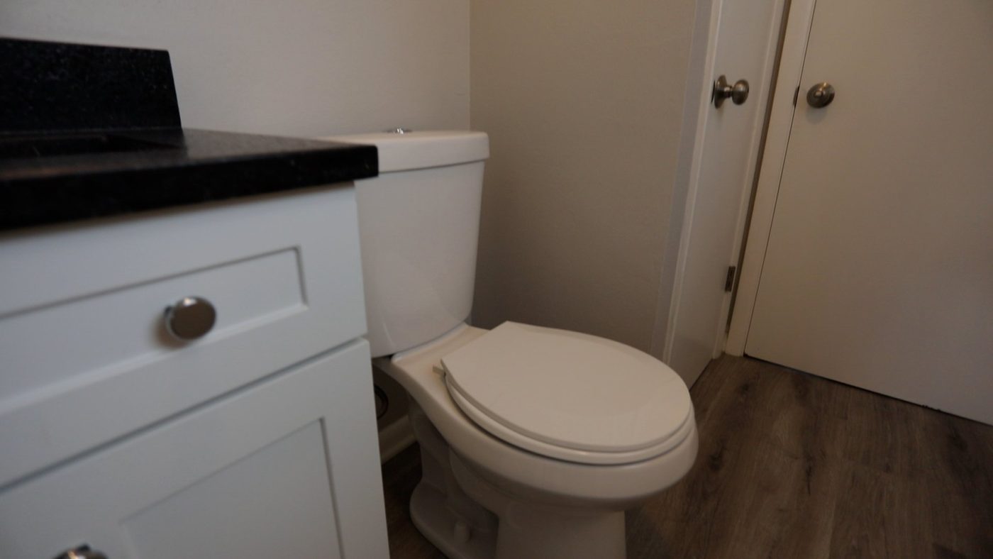 A bathroom with a toilet , sink , and door.