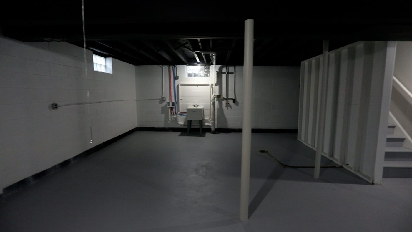 An empty basement with a toilet and stairs